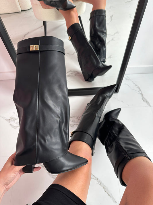 Black knee-high boots being worn with a marble floor background